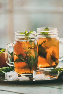 Summer refreshing cold peach ice tea on tray  vertical composition