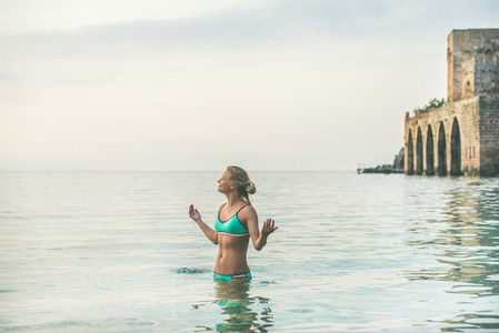 Young woman in blue bikini relaxing in sea in Alanya