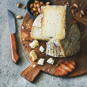 Cheese platter with nuts  honey and bread  square crop
