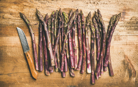 Fresh purple asparagus over wooden background