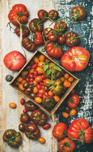 Flat  lay of fresh colorful tomatoes over rustic background