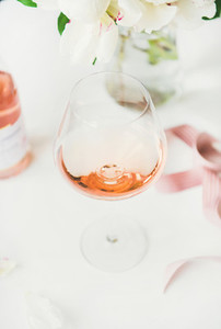 Rose wine in glass pink ribbon peony flowers