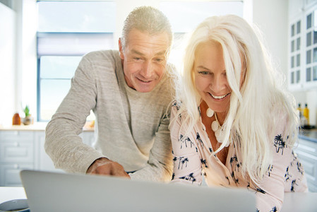 Excited senior couple looking at a laptop together