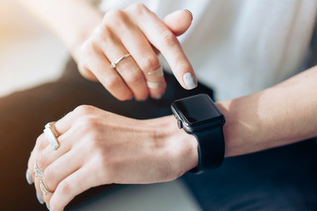 Womans hand touching the screen of a smart watch