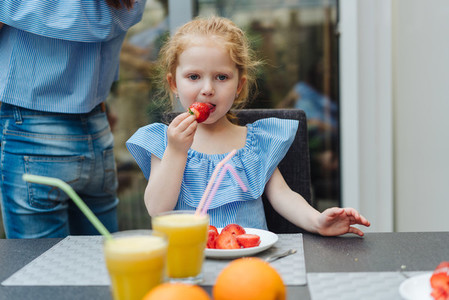 Little girl eating fresh strawberries