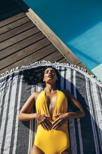 Woman sunbathing at poolside