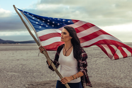 Woman holding a USA flag on the beach