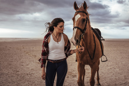 Equestrian walking with a stallion in evening