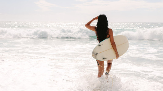 Female surfer going on surf in the sea