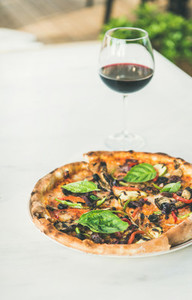 Freshly baked vegetarian pizza and glass of wine