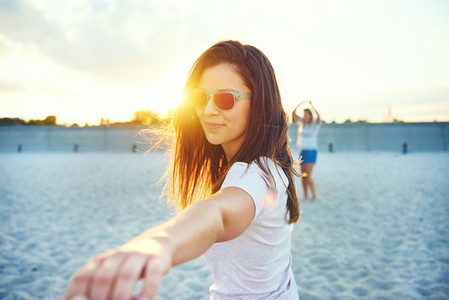 Woman in sunglasses reaching hand outward