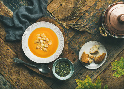 Warming pumpkin cream soup with croutons and seeds