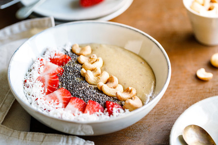 Smoothie bowl with banana  matcha  coconut cream  strawberry  cashew and chia seeds  Healthy vegan eating