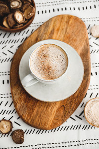 Mushroom latte with Shiitake powder and vegetarian blend milk on a wooden tray on a table  Healthy useful vegan drink