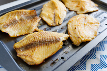 Close up of tilapia fillets on a broiling pan  Recipe for healthy home dinner or lunch