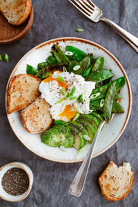 Top view of healthy breakfast or lunch  Fried snow peas  avocado  poached eggs are sprinkled chia seeds with toasts