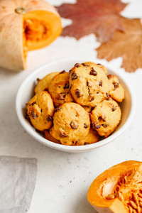 Pumpkin cookies with chocolate chips made from cake mix in a white ceramic bowl