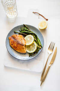 Roasted tilapia fish with asparagus on a ceramic plate  Healthy mediterranean diet lunch or dinner  Top view  flat lay