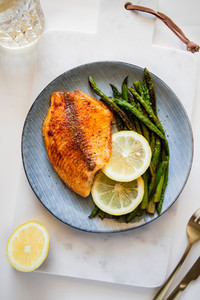 Roasted tilapia fish with asparagus on a ceramic plate  Healthy mediterranean diet lunch or dinner  Top view  flat lay