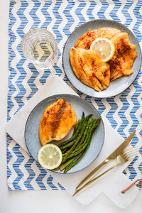 Baked tilapia fish with asparagus on a ceramic plate  Healthy mediterranean diet lunch or dinner