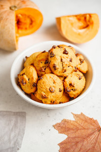 Pumpkin cookies with chocolate chips made from cake mix in a white ceramic bowl