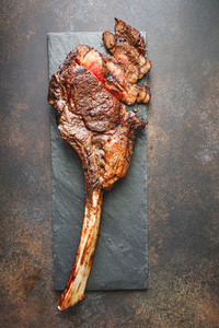 Top view of dry aged marble beef steak Tomahawk on black slate with spices  Flat lay  dinner concept