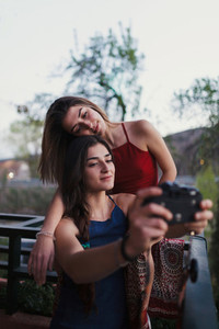 Two young women take a selfie on the balcony