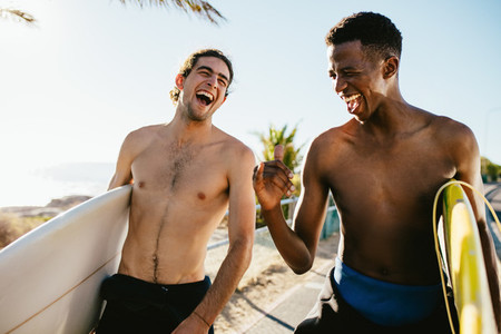 Cheerful friends going water surfing on holiday