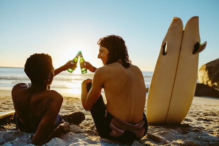 Surfers toasting beers on the beach