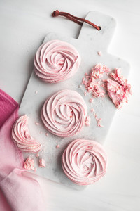 Top view of pink meringue on a white marble tray  Flat lay composition