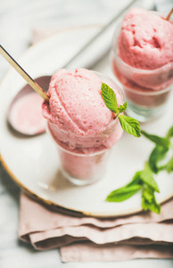 Homemade strawberry yogurt ice cream with mint in glasses