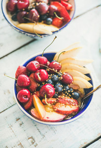 Healthy smoothie bowl with fruit and berries over wooden background