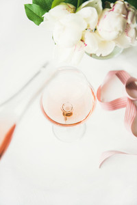 Rose wine in glass pink ribbon peony flowers vertical composition
