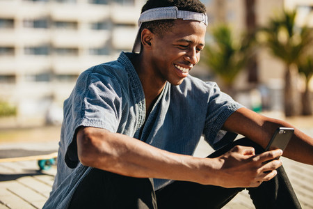 Skateboarder smiling with a mobile phone