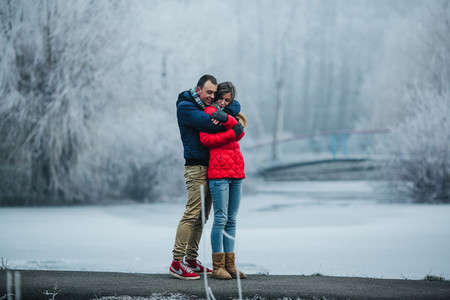 beautiful couple posing near a frozen river