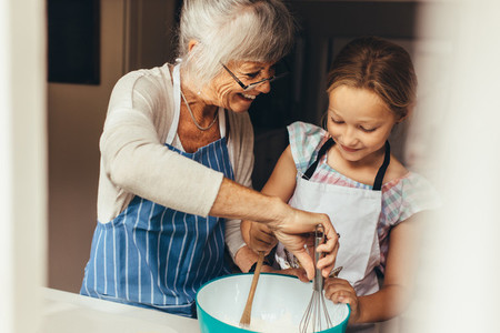 Granny and kid cooking in kitchen