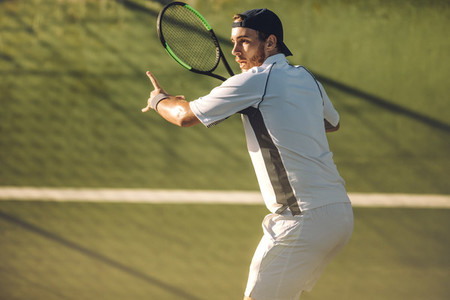 Tennis player returning the serve with a forehand