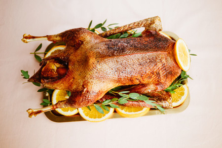 Whole roasted goose with oranges on a golden tray for celebrate event or Christmas family dinner