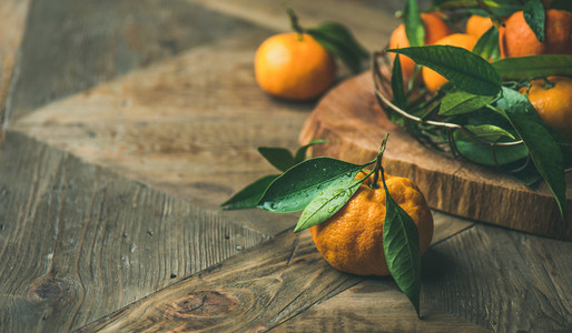 Fresh tangerines with leaves on board  copy space  horizontal composition