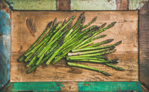 Raw uncooked green asparagus over rustic background  horizontal composition