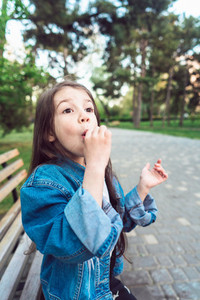 Girl sitting on bench with candies