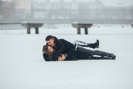 Girl and guy lie on snow