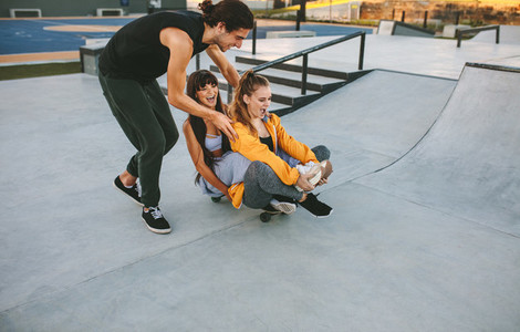 Friends playing with skateboard at skate park