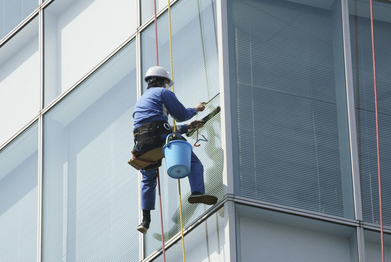 Harnessed window washer cleaning highrise windows #01