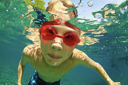 Portrait boy in swimming goggles swimming underwater 01