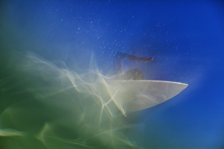 Underwater view of female surfer paddling out on surfboard 01