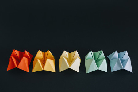 Rainbow multicolored origami fortune tellers on black background 01