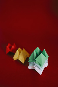Multicolored origami fortune tellers on red background 01