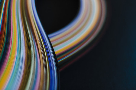 Abstract rainbow paper wave pattern on black background 01