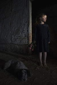 Serene girl with flowers and dog in dark barn 01